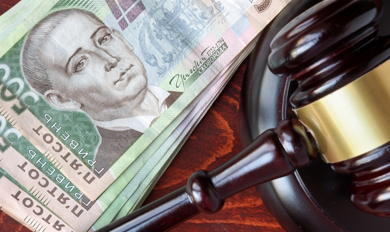 Gavel and Ukrainian hryvnias on a wooden table