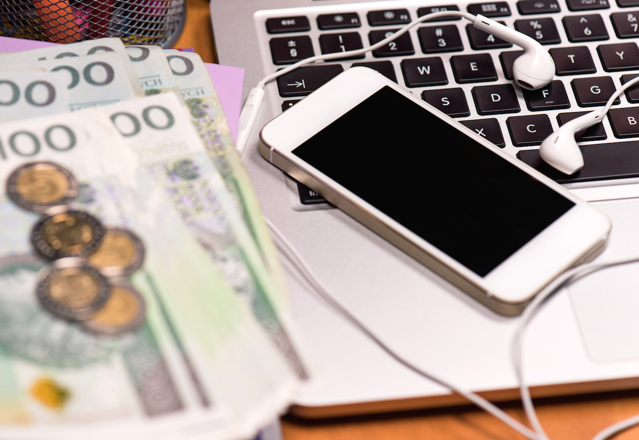 Workplace with money and electronic devices – cellphone, headphones for music and laptop computer. M