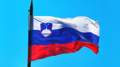 Slovenia flag against blue sky waving in wind