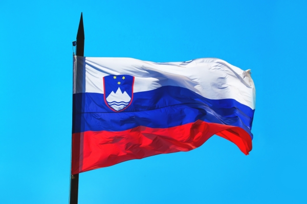 Slovenia flag against blue sky waving in wind