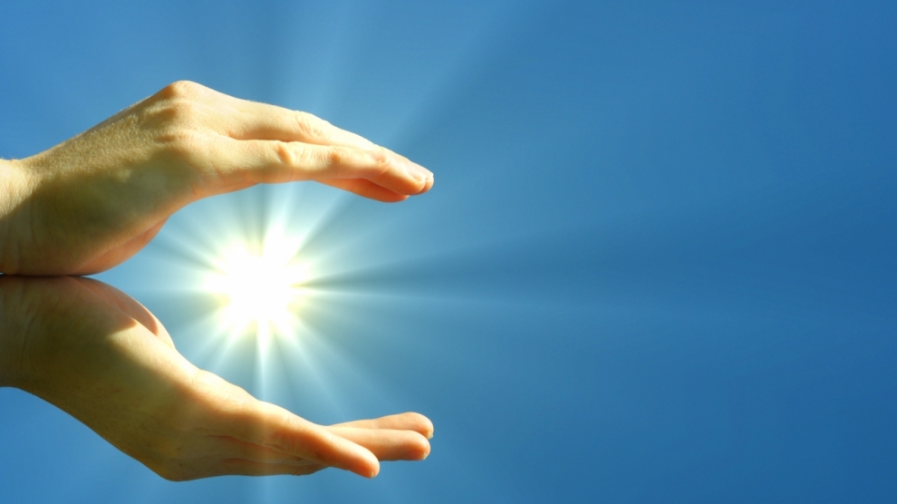 hand sun and blue sky with copyspace showing freedom or solar power concept
