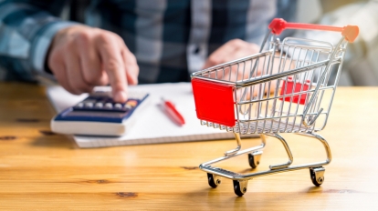 Rising food and grocery store prices is estonia and cost of living concept. Man counting food and consumer goods money with pen, paper and calculator at home. Budget of disadvantaged and low income family.