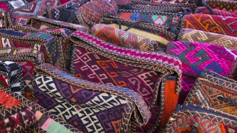 Bags headgear boxes made of traditional fabrics of Armenian patterns and colors lying on the stalls at the Yerevan market in Armenia