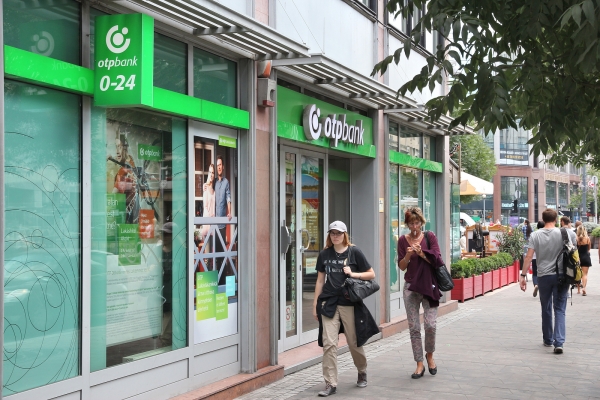 BUDAPEST HUNGARY - JUNE 22 2014: People walk by OTP Bank in Budapest. OTP is the biggest commercial Hungarian bank with 1500 branches in 9 countries.