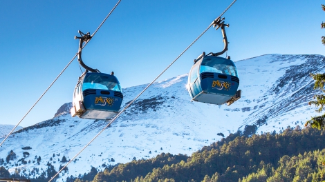 Bansko, Bulgaria - December, 6, 2015: Two Bansko cable car cabins and snow mountains peaks