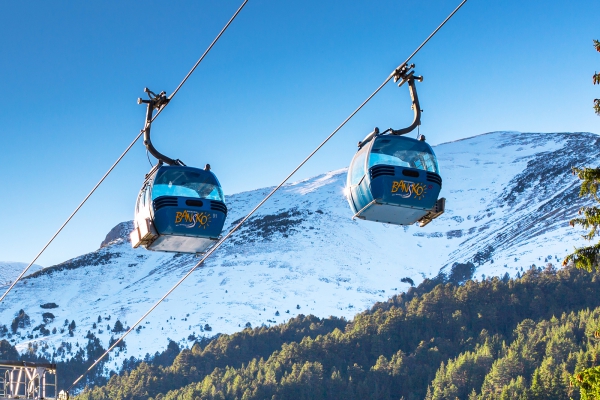 Bansko, Bulgaria - December, 6, 2015: Two Bansko cable car cabins and snow mountains peaks