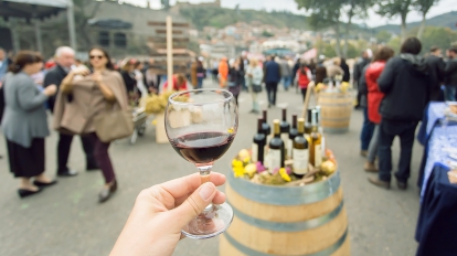 Glass of wine at tasting area of annual city festival Tbilisoba with crowd of people around. Tbilisi, the capital of Georgia country