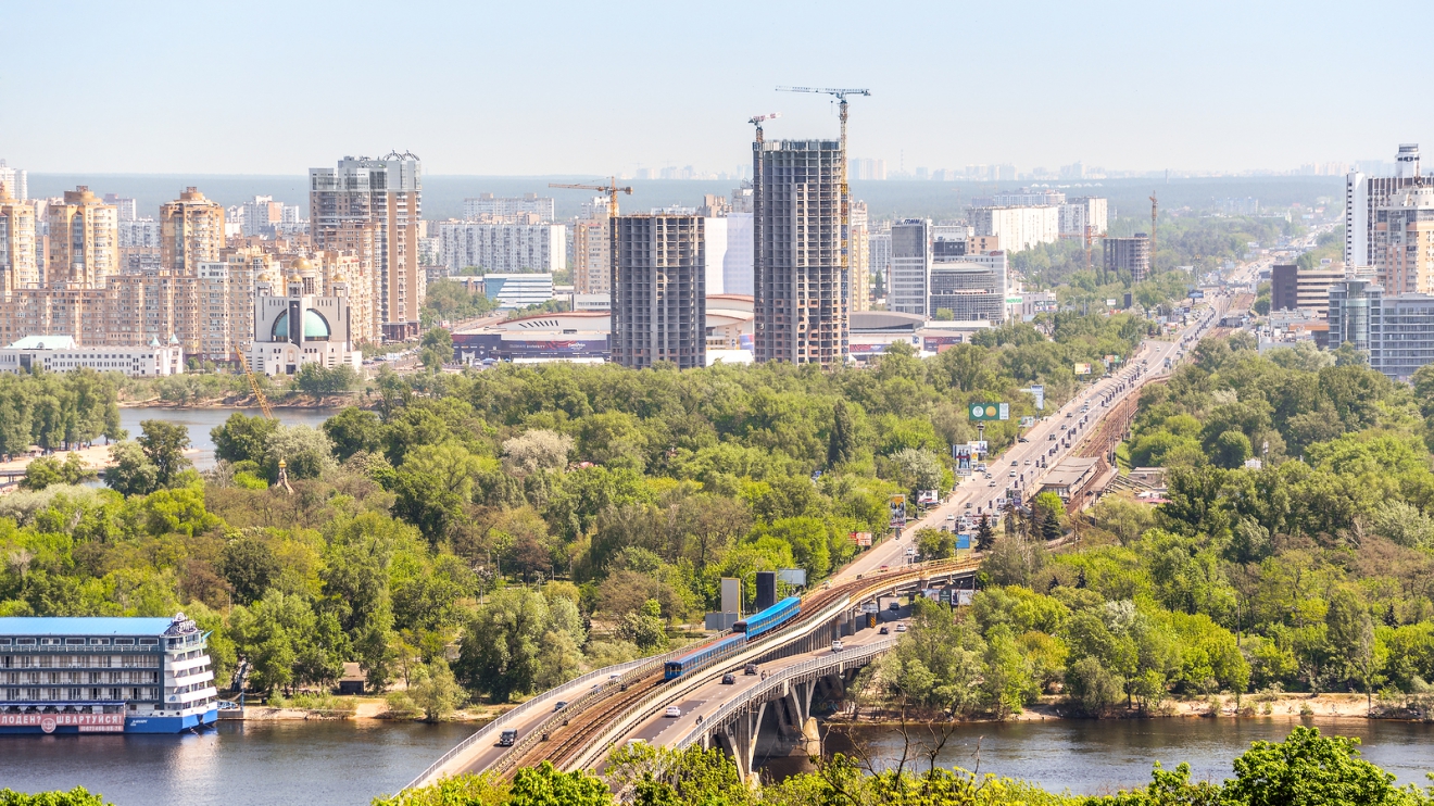 Kiev, Ukraine - May 15, 2017: Beautiful Kiev cityscape with bright green trees, river dnepr and buildings on the left river bank. Kiev, Ukraine.
