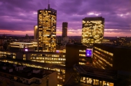 Prague skyscrapers in blue hour with purple sky. Modern building architecture after sunset. Office center in capital city. Czech republic lighting buildings.