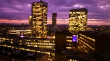 Prague skyscrapers in blue hour with purple sky. Modern building architecture after sunset. Office center in capital city. Czech republic lighting buildings.