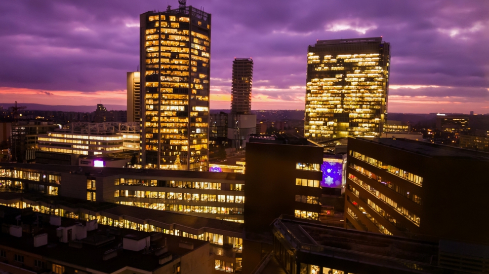 Prague skyscrapers in blue hour with purple sky. Modern building architecture after sunset. Office center in capital city. Czech republic lighting buildings.