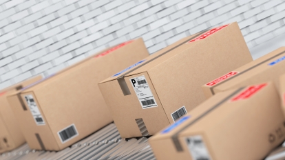 Parcels Transportation System Concept. Cardboard Boxes on Conveyor in Warehouse in front of brick wall. 3d Rendering