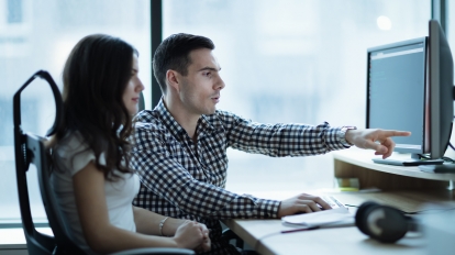 IT colleagues developing software together in office