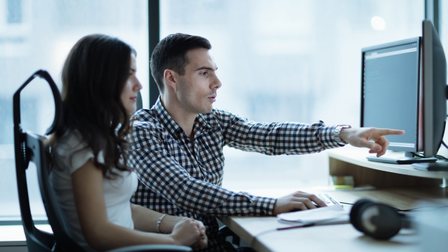 IT colleagues developing software together in office