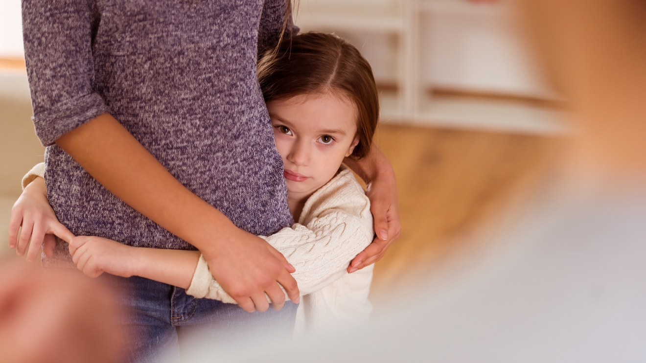 Child hugs her mother and protects her from evil father during an argument at home