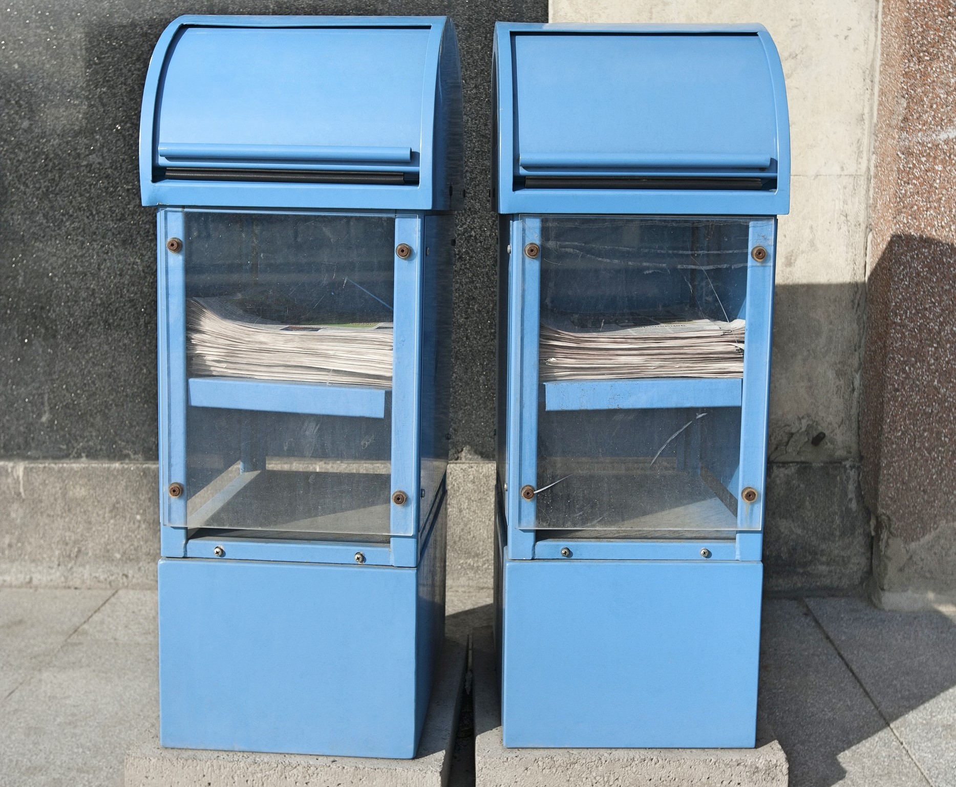 Blue newspaper dispensers on sidewalk; Tallinn; Estonia; Europe